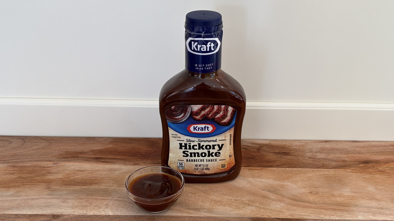 Kraft Hickoy Smoke BBQ sauce bottle on cutting board next to dish of sauce