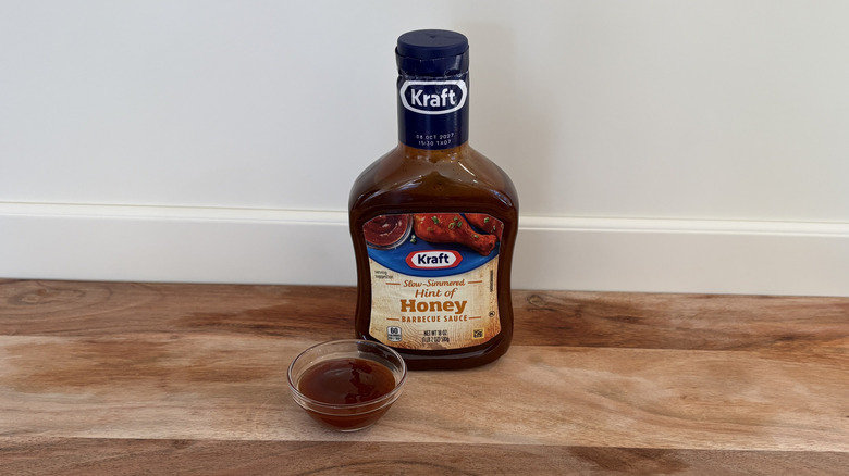 Kraft Hint of Honey BBQ sauce bottle on cutting board with small dish of sauce