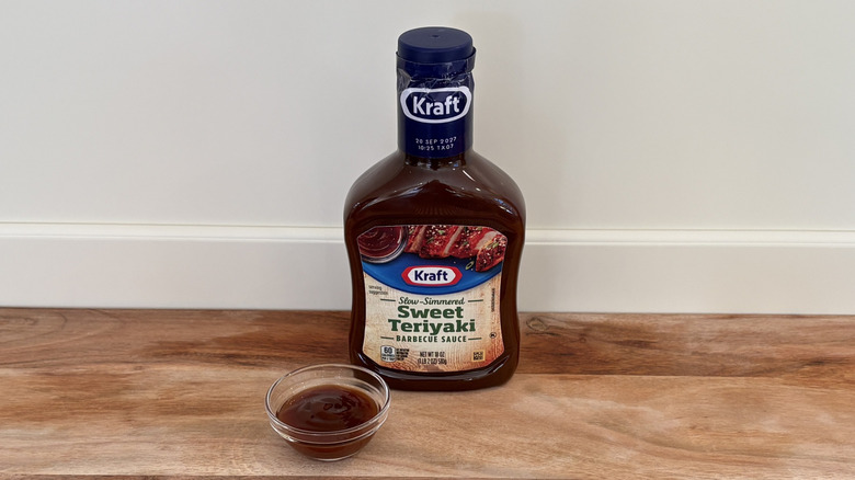 Kraft Sweet Teriyaki BBQ sauce bottle on cutting board with small glass dish of sauce