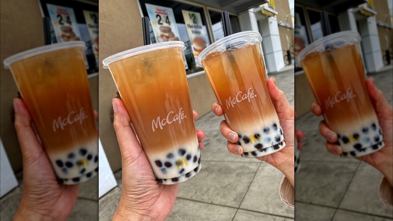 Two McCafé cups with boba tea pearls in the bottom, milk and black coffee.