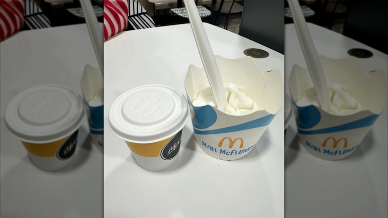 A cup of McDonald's espresso coffee and a mini McFlurry with a spoon in it.
