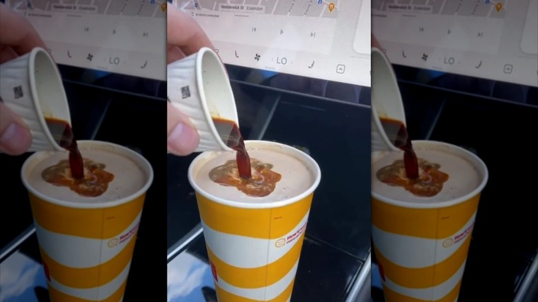 A shot of espresso being poured into a McDonald's vanilla milkshake with a screen in the background.