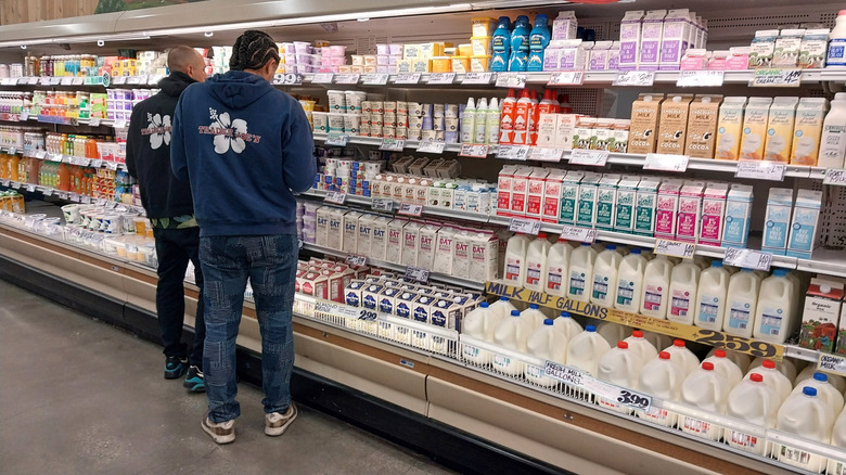 Two Trader Joe's employees standing in dairy aisle