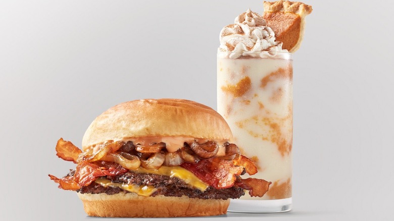 A Freddy's Smoky Bacon Cheddar Stack with a pumpkin pie shake in the background.