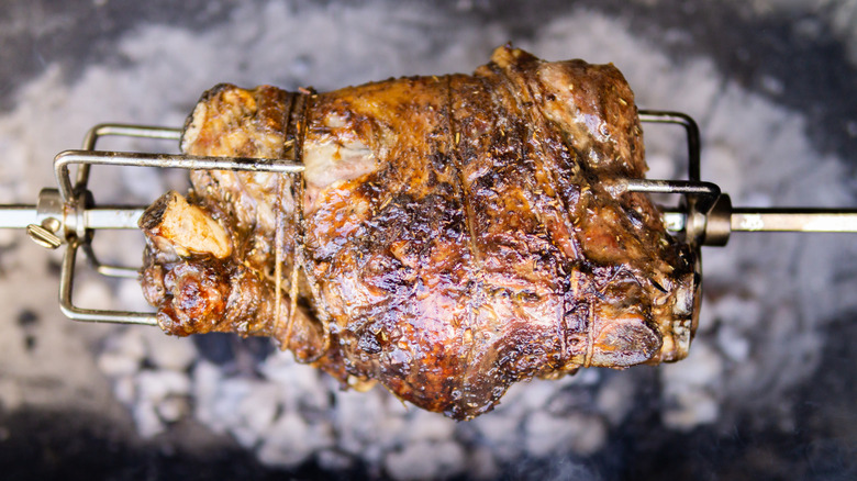 Barbecued mutton on a spit roaster over charcoal