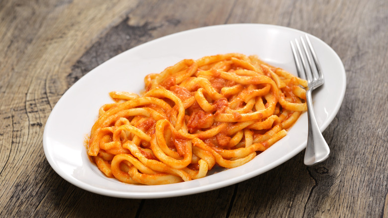 Pici all'aglione on a white plate