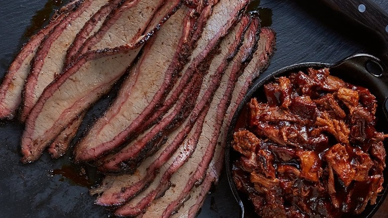 Joe's KC brisket on black surface with cast iron of sides