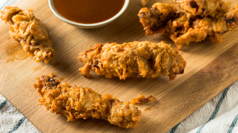 Idaho finger steaks on a wooden cutting board with a dipping sauce