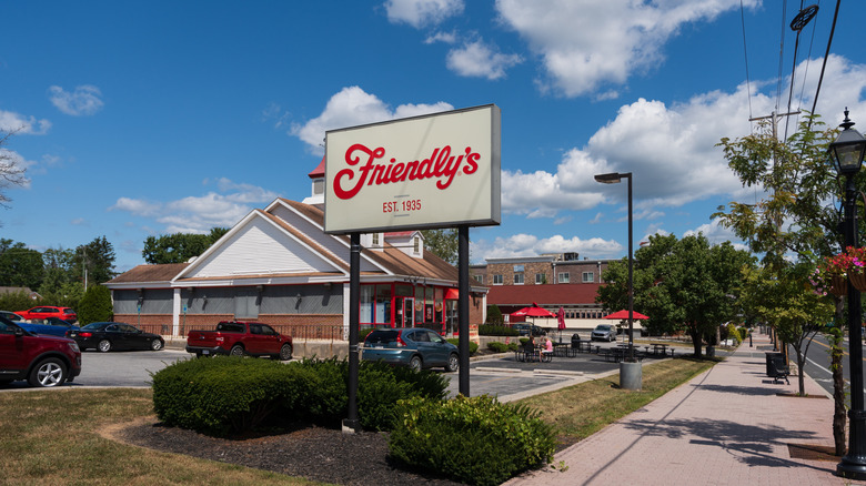 Friendly's restaurant sign outside building and parking lot, taken from sidewalk