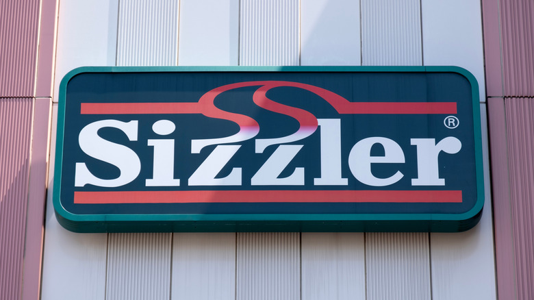 Sizzler restaurant sign on a building wall