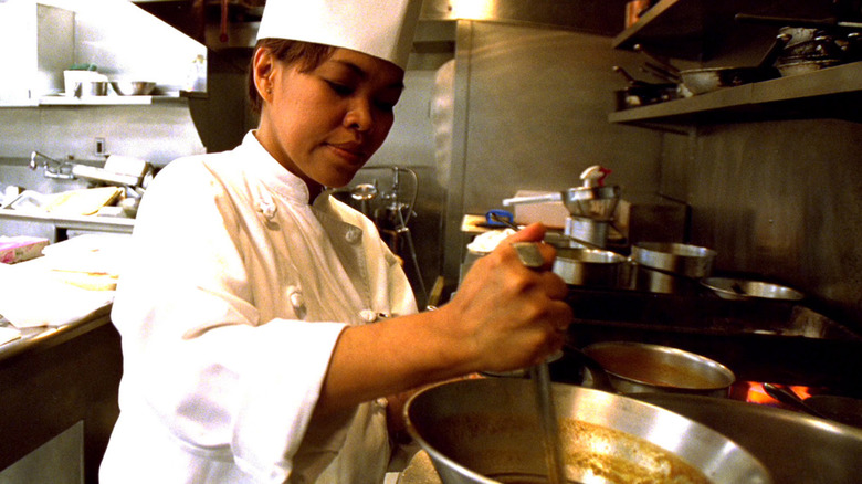 White House chef ladles brown liquid from a pot on the White House stove