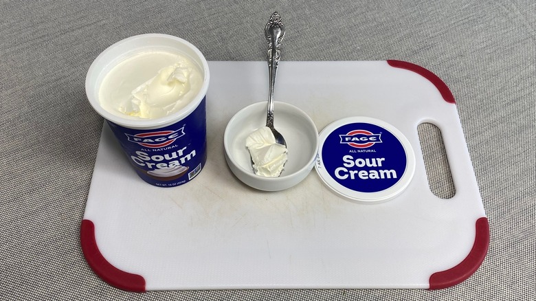 Sour cream in a spoon alongside the packaging