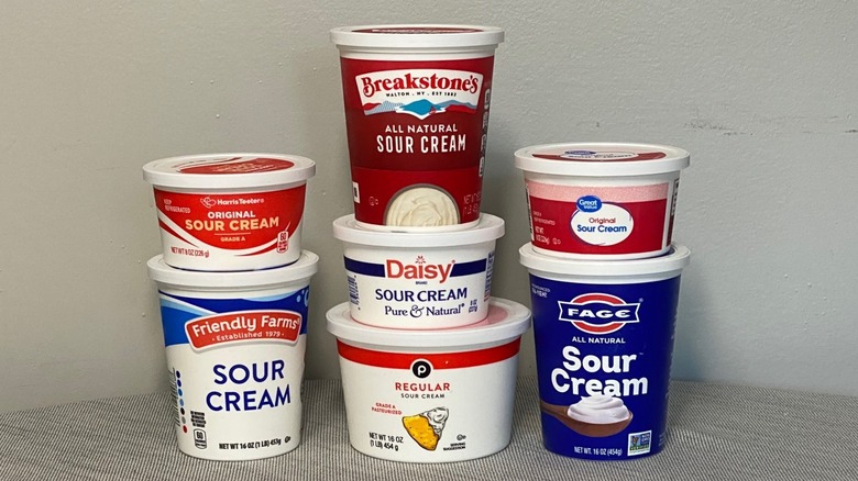 Seven sour cream brands stacked on a countertop