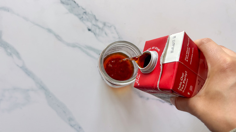 Pouring Stash chai concentrate into a glass