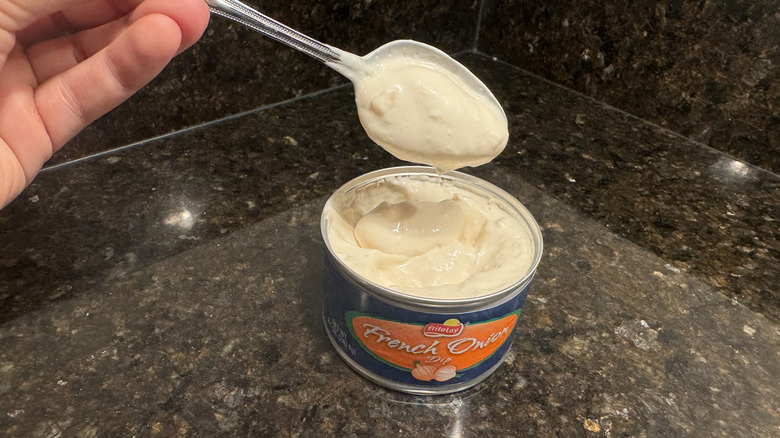 French onion dip with spoon and hand