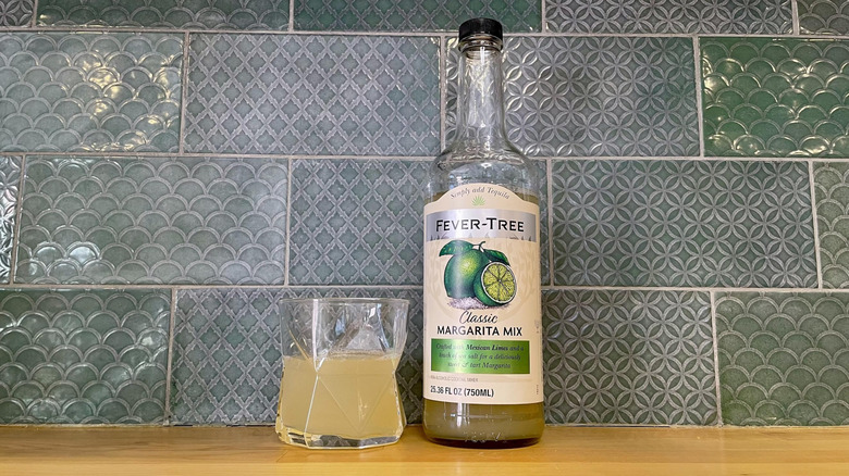 Bottle and glass Fever-Tree Classic Margarita Mix on a wooden counter top
