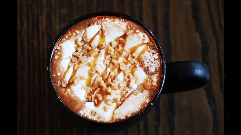 A mug of hot chocolate topped with caramel and toffee