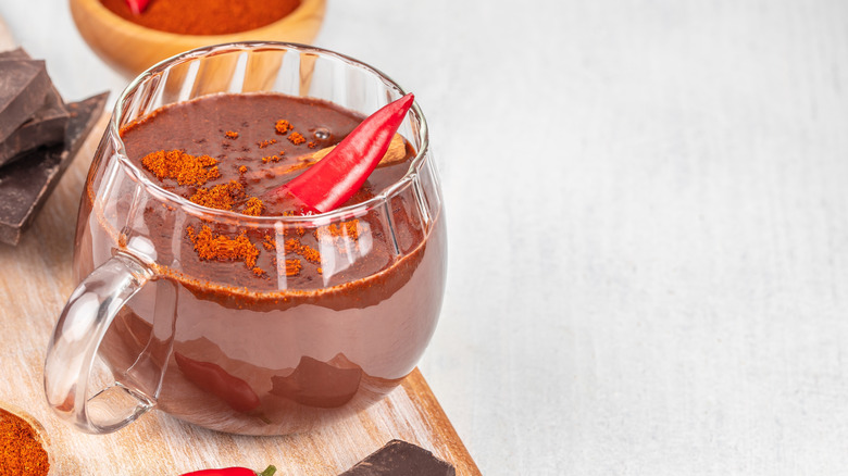 Hot chocolate topped with a chili pepper and cayenne powder