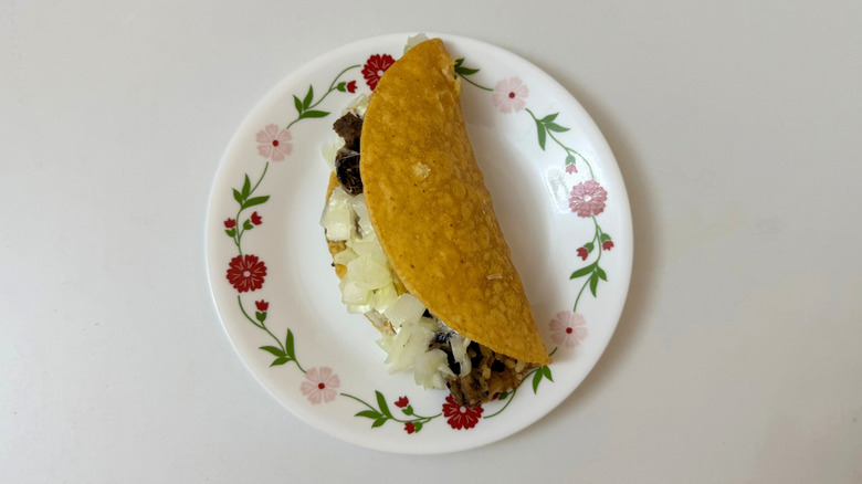 Moe's Taco with onions and steak on small, white plate