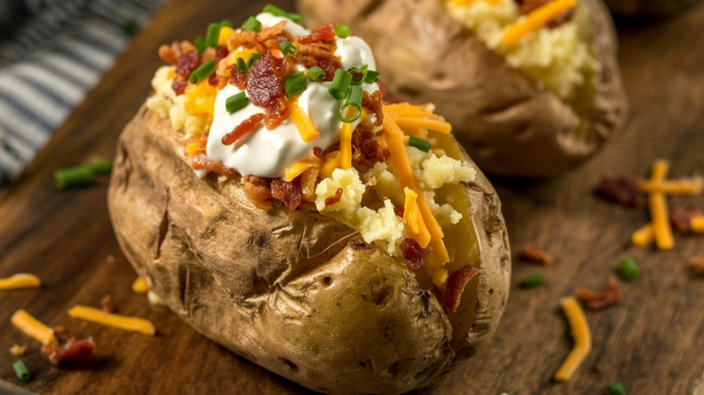 A classic loaded baked potato topped with scallions, shredded cheese, cream cheese, and salsa