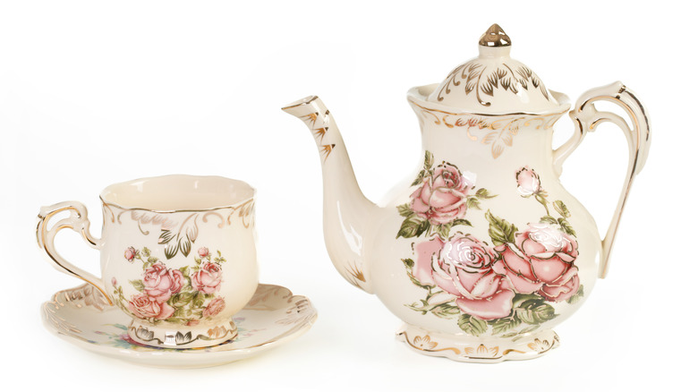 A vintage tea cup and pot with floral designs