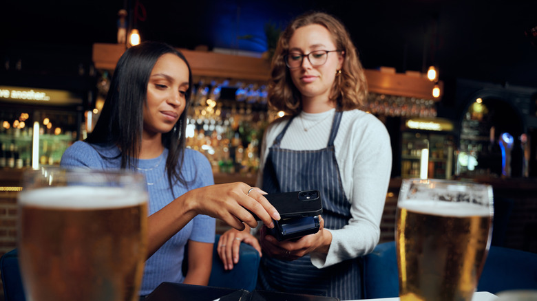 Woman paying for drinks with her phone