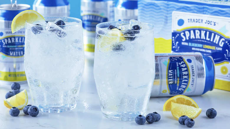 Glasses and cans of Trader Joe's sparkling water with blueberries and lemon