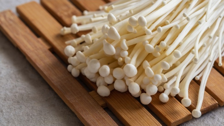 Enoki mushrooms on a wooden board