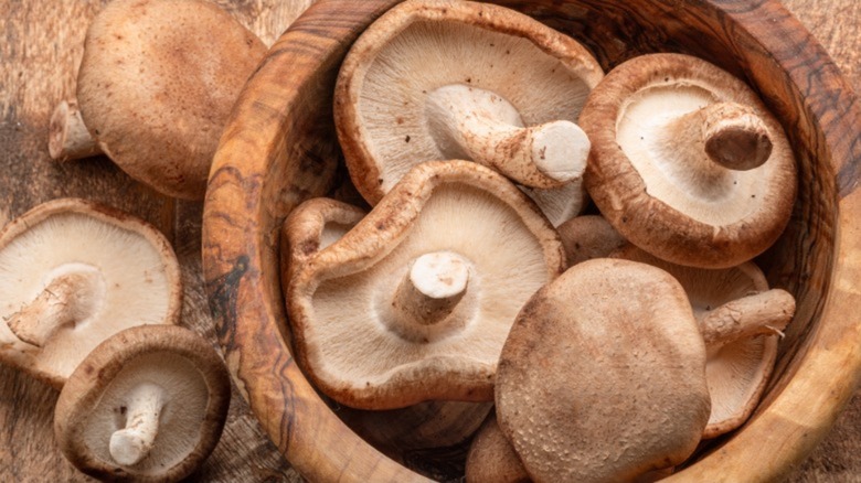 Raw shiitake mushrooms in a wooden bowl
