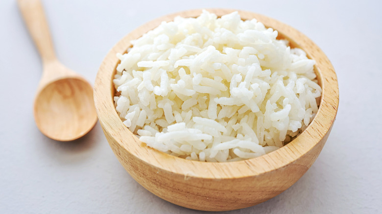 cooked jasmine rice in a wooden bowl with spoon