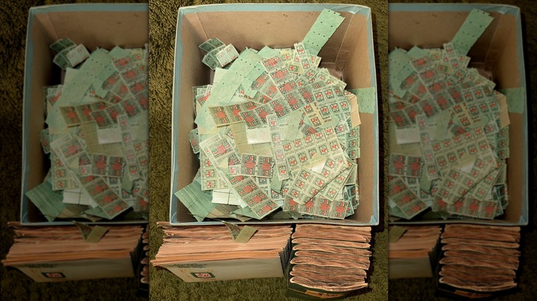 Box full of S&H Green Stamps on olive-colored shag carpet