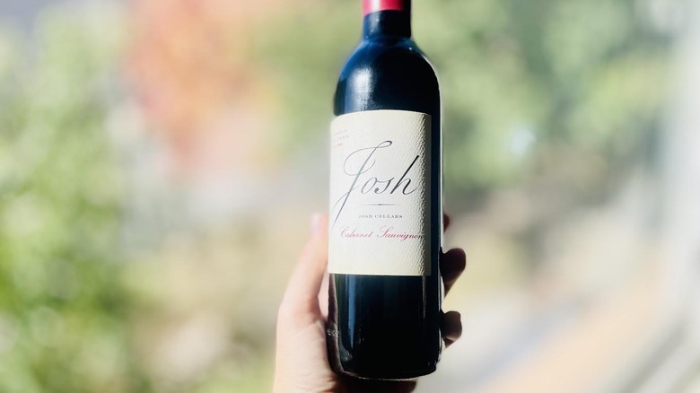 Hand holding bottle of Josh Cellars Cabernet Sauvignon