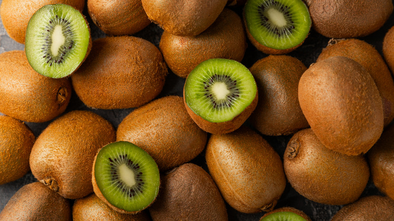 Array of whole and halved kiwi fruits