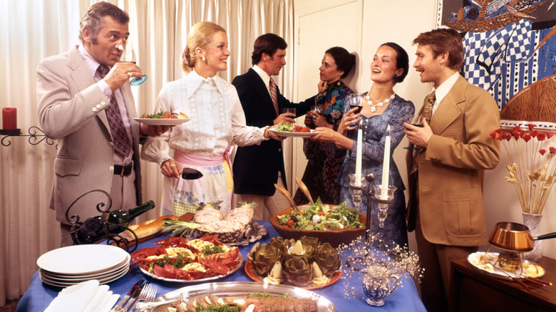 A group of people at a dinner party in the 1970s.
