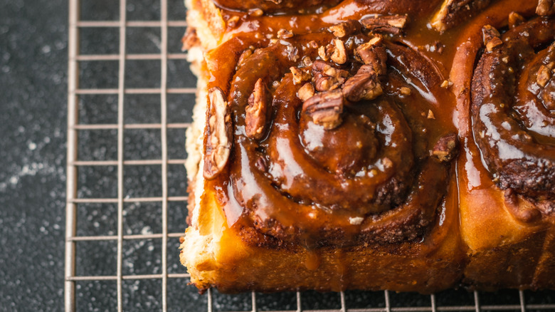 Overhead shot of caramel pecan cinnamon rolls on a cooling rack