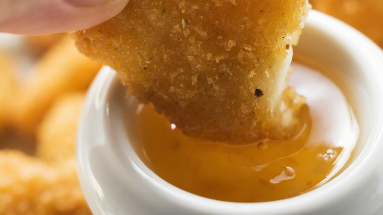 Close up of McNugget being dipped into sauce