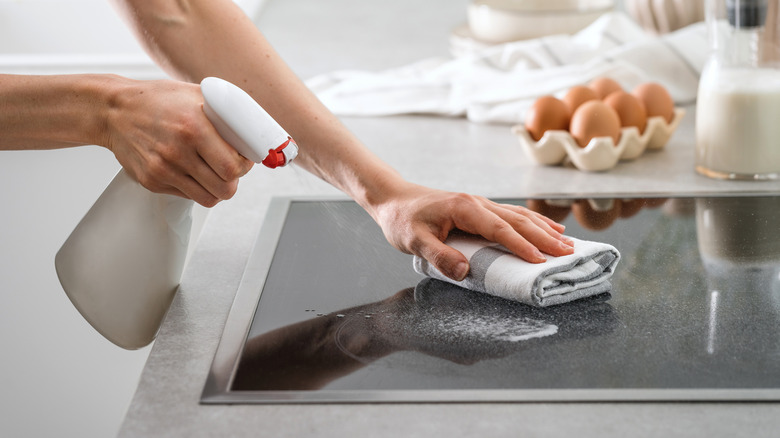 Person cleaning a glass cooktop