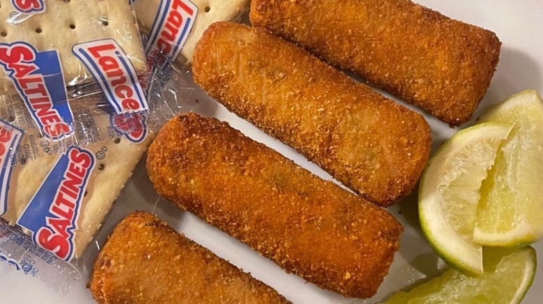 Croquetas from Islas Canarias on a plate with Cuban saltine crackers and lime wedges.