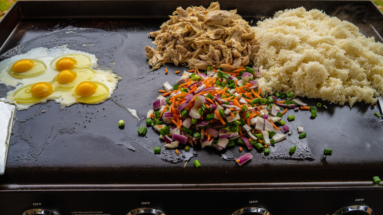 Ingredients for chicken fried rice being cooked on Blackstone griddle
