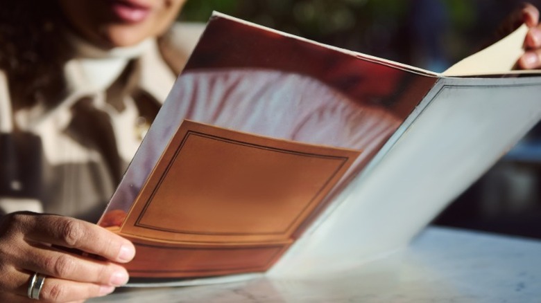 A customer inspecting a restaurant menu