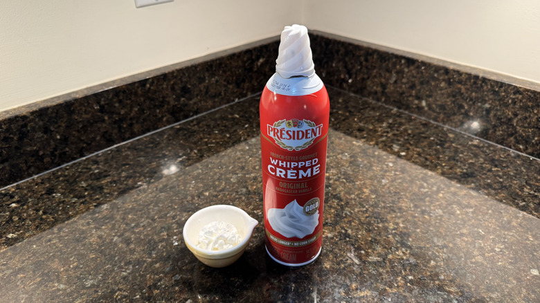 Président canned whipped cream beside filled white dish on countertop