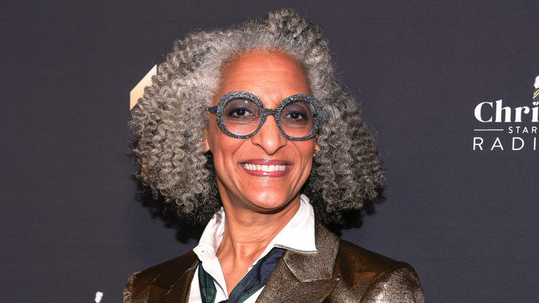 Chef Carla Hall smiling with speckled glasses on