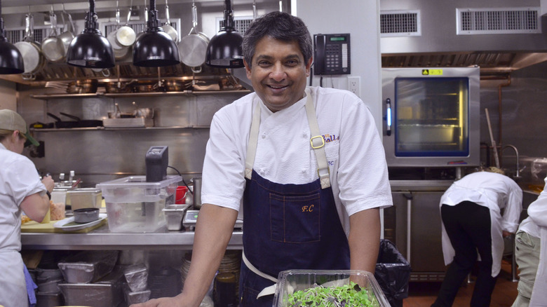 Chef Floyd Cardoz smiling in a restaurant kitchen
