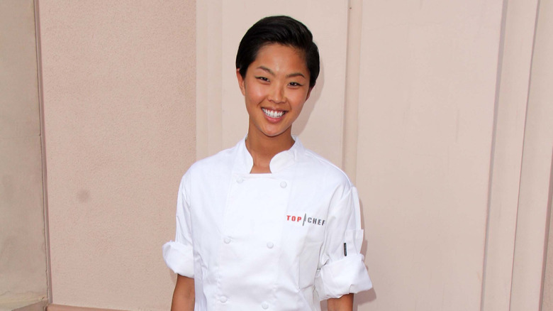 Kristen Kish wearing a chef's coat with the "Top Chef" logo