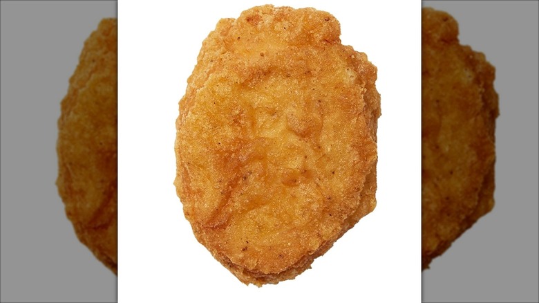 One McDonald's chicken nuggets on a white background