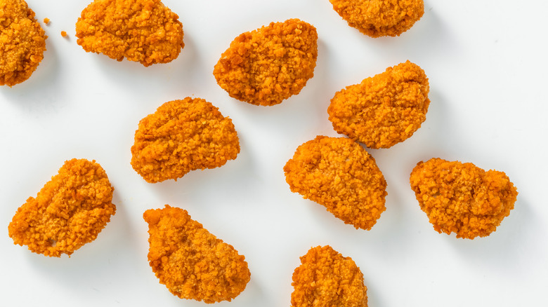 Chicken nuggets lying against a white background