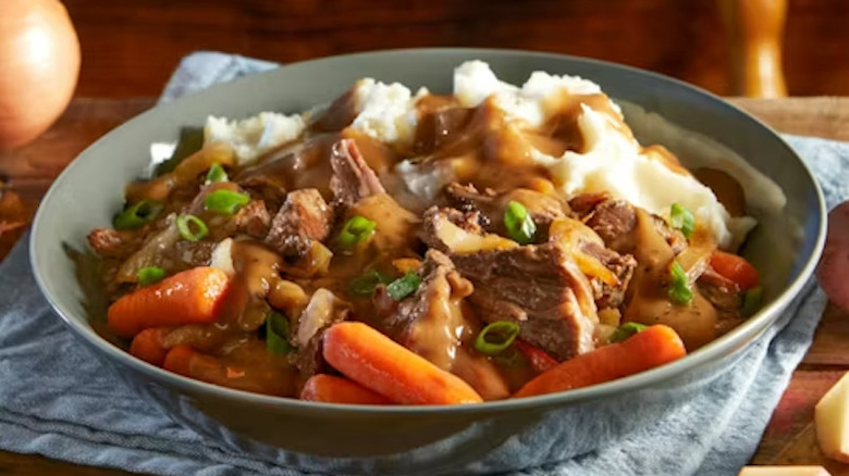 A bowl of pot roast with mashed potatoes, vegetables, and gravy at Bob Evans