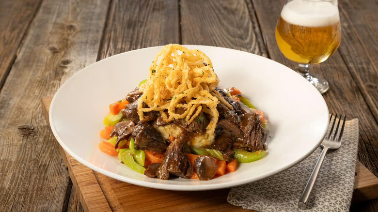 A plate of short rib pot roast with, mashed potatoes, vegetables, and crispy onions at Houlihan's