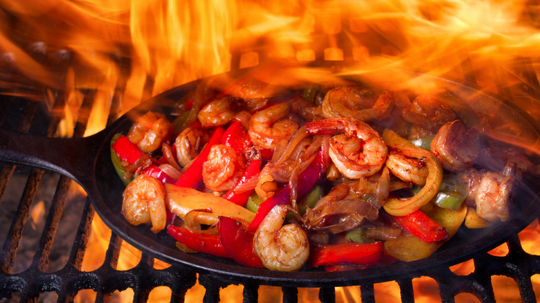 Fajitas cooking on a grill over a fire