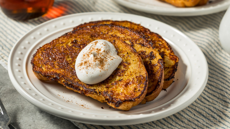 Three slices of French toast with a dollop of whipped cream